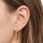 Close-up of the Lelice Zoe Spiral Earrings in gold on the ear