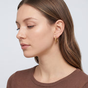 Model wearing the Lelice Zoe Spiral Earrings in gold, side profile portrait