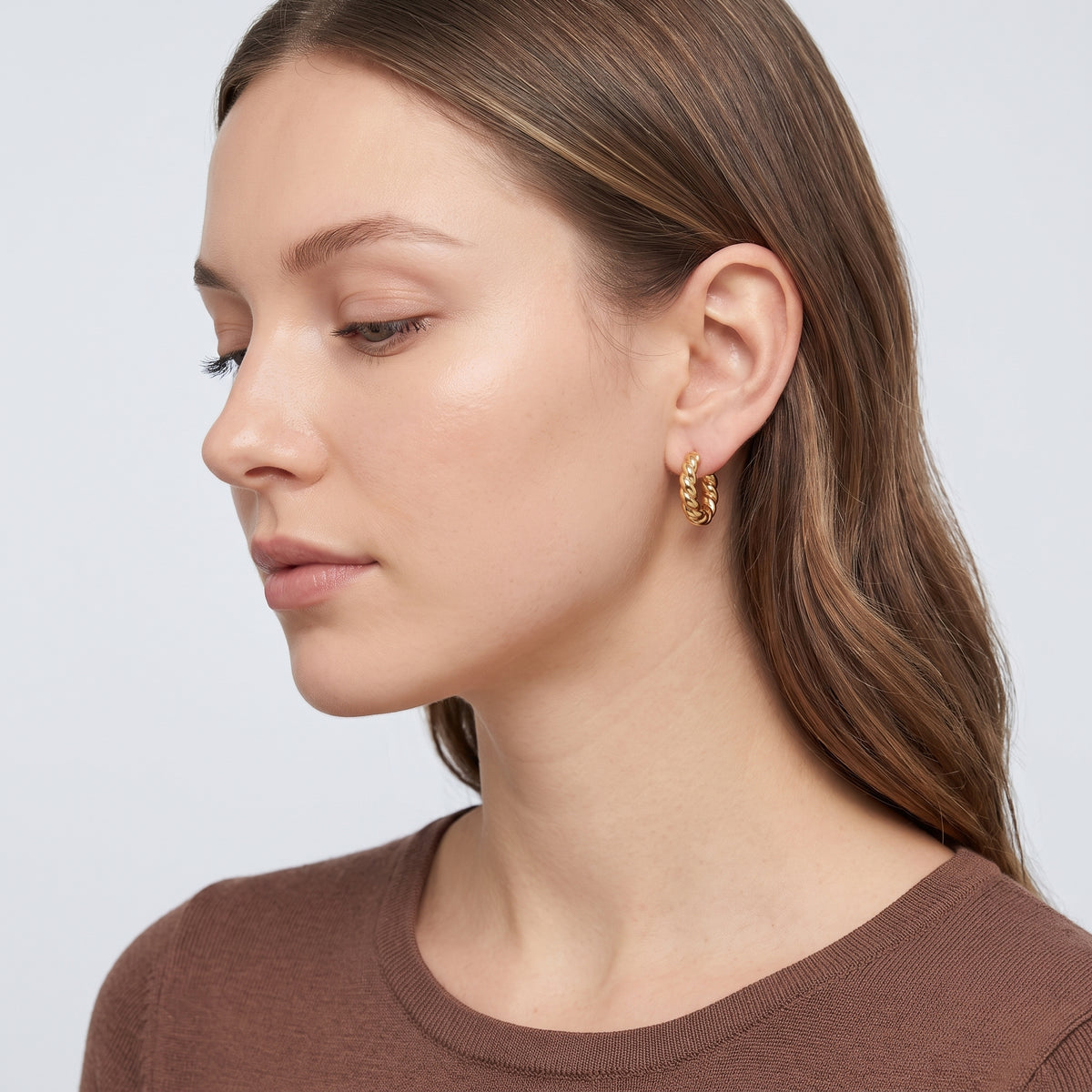 Model wearing the Lelice Zoe Spiral Earrings in gold, side profile portrait