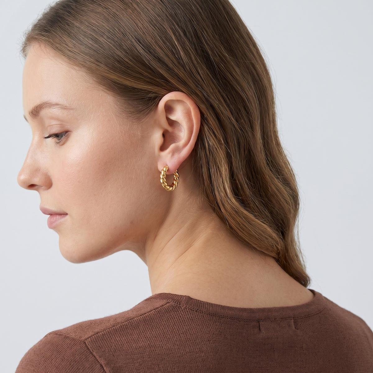 Model wearing the Lelice Zoe Spiral Earrings in gold, three-quarter back view